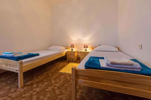two twin beds in a room with two lamps at Three-Bedroom Apartment in Crikvenica XIII in Sopaljska