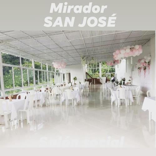a banquet hall with white tables and white chairs at Mirador San Jose in Santa Rosa de Cabal