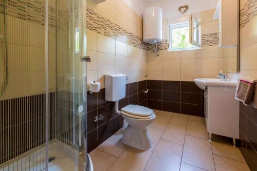 a bathroom with a toilet and a sink and a shower at One-Bedroom Apartment in Crikvenica XVIII in Dramalj