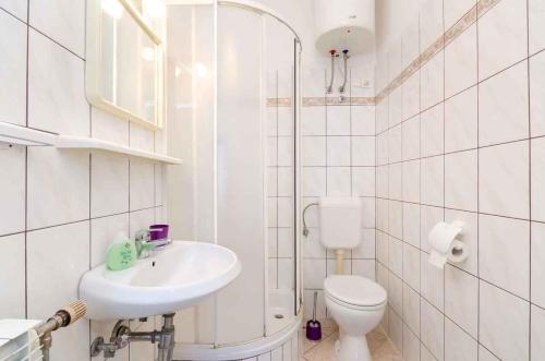 uma casa de banho branca com um WC e um lavatório em Two-Bedroom Apartment in Crikvenica XXXIII em Sopaljska