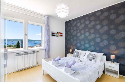 um quarto com uma cama grande e uma janela grande em Two-Bedroom Apartment in Crikvenica XXXIII em Sopaljska