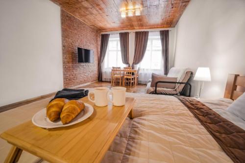 Un dormitorio con una cama con una mesa con cruasanes. en Luxury apartment with Rynok square view, en Leópolis