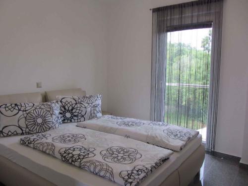 a bed in a room with a large window at Two-Bedroom Apartment in Malinska/Insel Krk 13080 in Sveti Vid-Miholjice