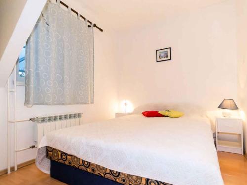 a bedroom with a white bed and a window at Apartment in Njivice/Insel Krk 13305 in Njivice