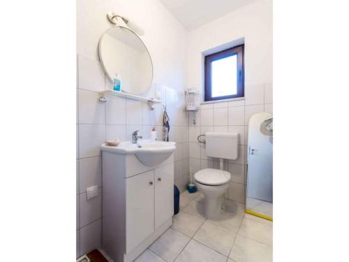 a bathroom with a toilet and a sink and a mirror at Apartment in Njivice/Insel Krk 13305 in Njivice