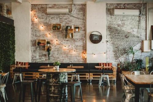 a restaurant with tables and chairs and a brick wall at CarricHouse in Melbourne