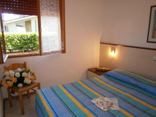 a bedroom with a bed and a vase of flowers at Apartments in Bibione 24604 in Bibione