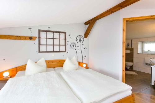 a bedroom with a large white bed and a bathroom at Studio in Gross Kordshagen I in Arbshagen