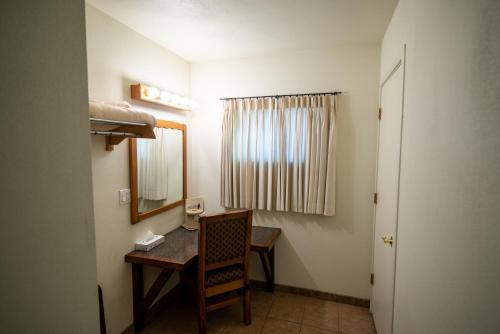 Cette petite chambre comprend un bureau et un miroir. dans l'établissement Reeds Lodge, à Springerville