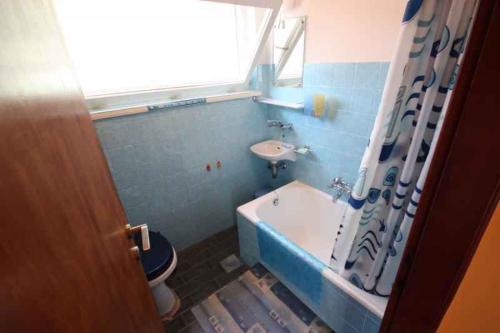 a blue bathroom with a tub and a sink at Holiday home in Crikvenica 5431 in Crikvenica