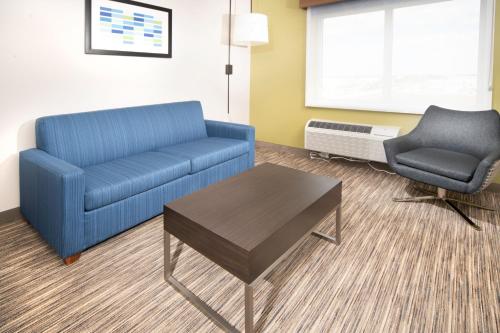 a living room filled with furniture and a blue couch at Holiday Inn Express & Suites - Fort Myers Airport, an IHG Hotel in Fort Myers