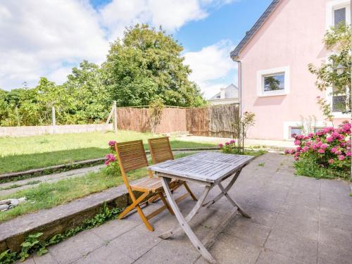 a table and chair in the backyard of a house at Apartment is approx 100 metres from the Atlantic in Le Pouldu