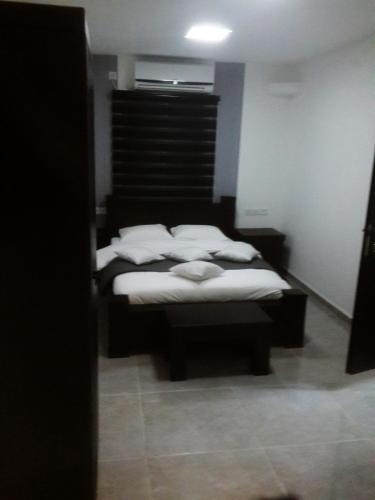 a bedroom with a bed with white pillows on it at City Apartments in Eilat