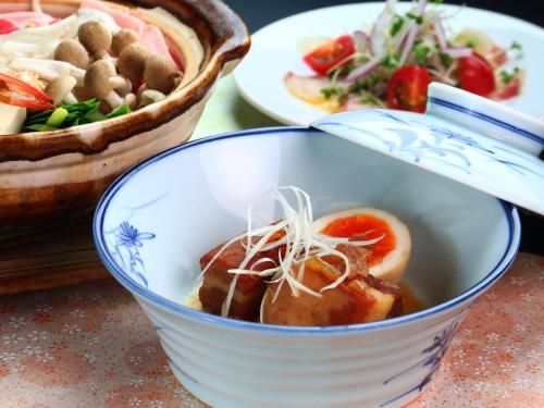 a bowl of food on a table with plates of food at Star Hotel Akakura in Myoko