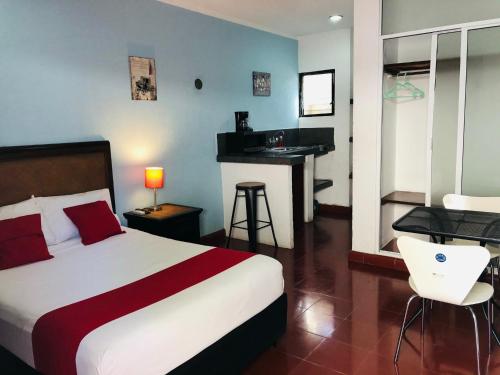 a hotel room with a bed and a desk in it at Hotel Dpas 52 in Mérida