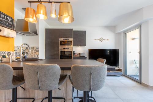 une cuisine avec une grande table et des chaises en bois dans l'établissement LB Vacation Rentals I Cannes Center, Renovated Apartment with Balcony, Ideal for Holidays or Congress!, à Cannes
