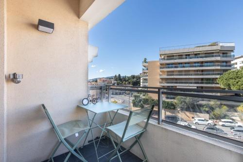 un balcon avec une table et des chaises et une vue dans l'établissement LB Vacation Rentals I Cannes Center, Renovated Apartment with Balcony, Ideal for Holidays or Congress!, à Cannes