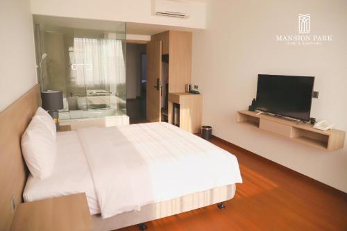 a bedroom with a bed and a flat screen tv at Mansion Park Hotel & Apartment in Bien Hoa