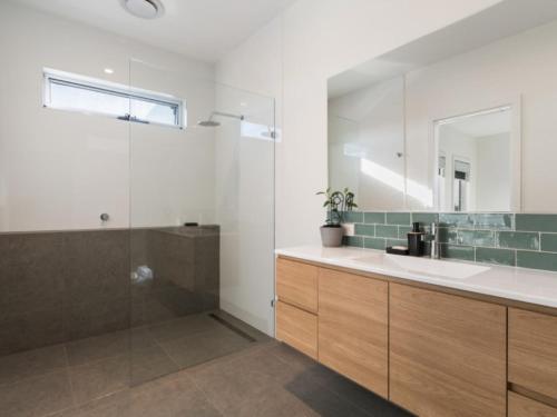 ein Badezimmer mit Waschbecken und Glasdusche in der Unterkunft Coastal Luxury in Rye