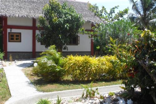 a house with a garden in front of it at Beach House Sibuyan via Cresta de Gallo in San Fernando