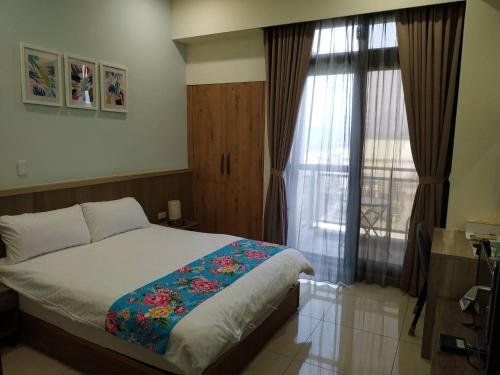 a bedroom with a bed and a window at Tung Shiang Homestay in Sanyi
