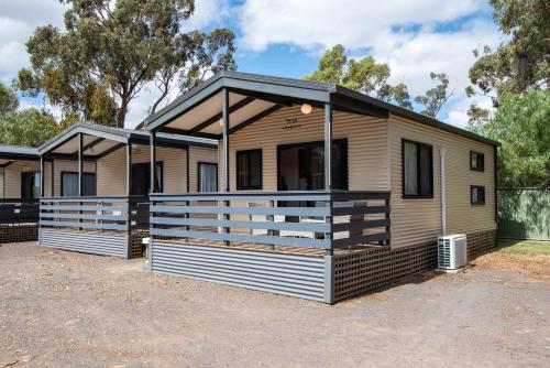 a modular home with a porch on a lot at Golden Country Motel and Caravan Park in Maryborough