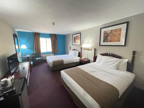Cette chambre comprend deux lits et une télévision. dans l'établissement Scenic Hills Inn, à Branson