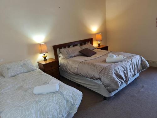 a bedroom with two beds and two lamps on tables at Truro weighbridge motel in Stockwell
