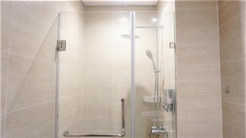 y baño con ducha y puerta de cristal. en Ecobay Halong -Mountain view and near Marina beach en Ha Long