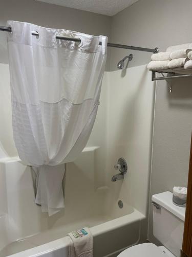 a bathroom with a shower with a white shower curtain at Scenic Hills Inn in Branson