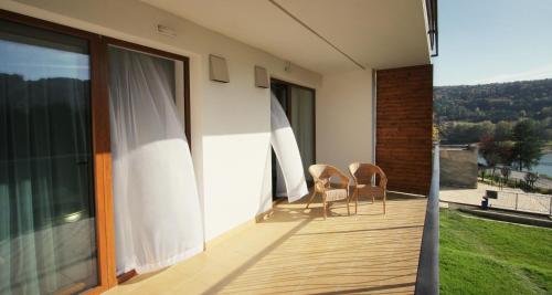 a balcony of a house with two chairs on it at Garden Hotel Domaša in Domaša Dobrá