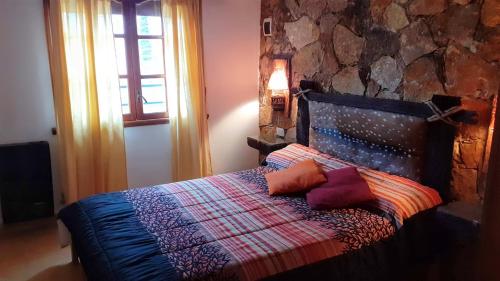 een slaapkamer met een bed met kussens erop bij Amancay in Tandil