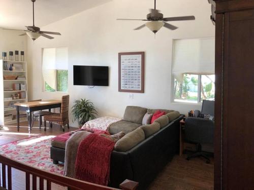 ein Wohnzimmer mit einem Sofa und einem Tisch in der Unterkunft Beautiful new detached casita nestled in scenic southern CA foothills! in Fallbrook