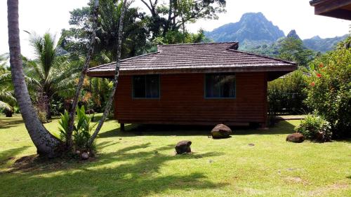 a small house in a yard with a grass field at Eco Lodge Village Temanoha in Paopao