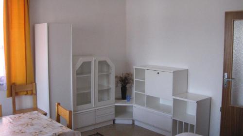 a dining room with a white cabinet and a table at Penzion Važec in Važec
