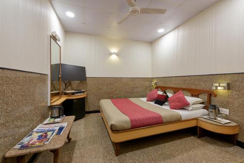 a hotel room with a bed and a television at Hotel Royal Castle in Mumbai