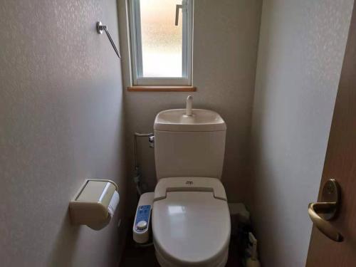 a small bathroom with a toilet and a window at 臨湖荘 in Takashima