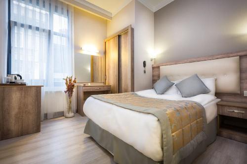 una habitación de hotel con una cama grande y una ventana en Fatih Hotel Corner, en Estambul