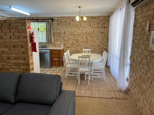 ein Wohnzimmer mit einem Tisch und weißen Stühlen in der Unterkunft Esperance Holiday Apartment in Esperance