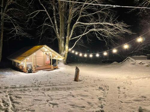 a cabin in the snow at night with lights at Torma Puhkemaja ja Glämping in Torma
