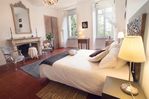 1 dormitorio con 1 cama grande y chimenea en H2o Chambres d'Hôtes, en Peyriac-de-Mer