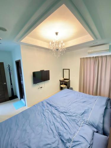 een slaapkamer met een groot bed en een televisie bij 葳葳民宿 in Magong