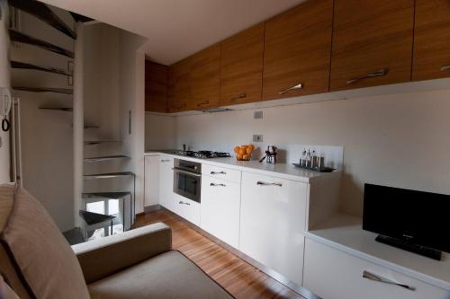 a small kitchen with white cabinets and a television at Torre Antica - Lombardia, Italy in Lovere