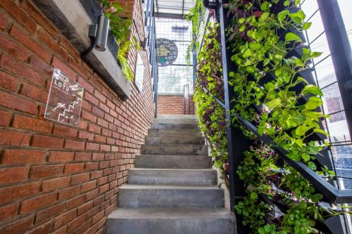 a stairway in a brick wall with plants at Sekararum Butik Syariah Guesthouse in Bandung