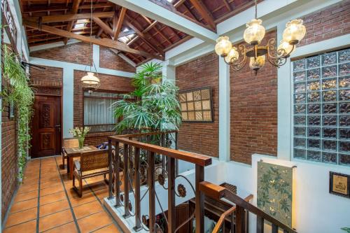 an indoor staircase with a brick wall and wooden ceiling at Sekararum Butik Syariah Guesthouse in Bandung