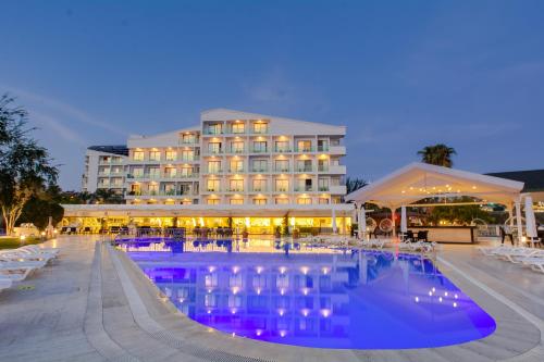 a hotel with a swimming pool at night at Falcon Hotel in Antalya