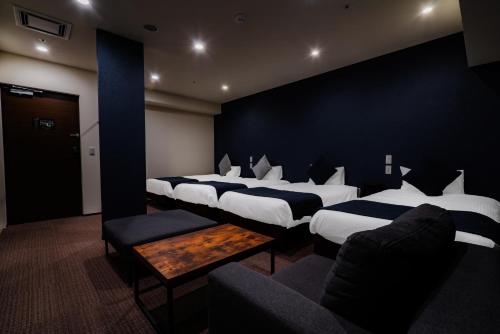 a room with a bunch of beds and a couch at Randor Hotel Sapporo Suites in Sapporo