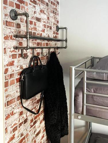 a brick wall with a black purse and a bag hanging on a wall at Eleonora Bed & Breakfast in Kristiinankaupunki
