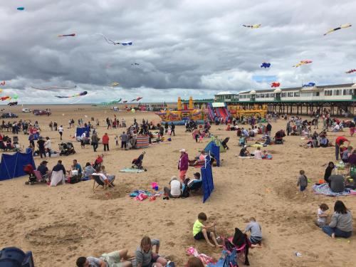 a crowd of people on a beach flying kites at Beach Snug in Lytham St Annes