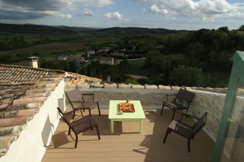 a patio with a table and chairs on a balcony at La Maison du Passage - Chambres - Suites premium, Spa, Piscine et Restaurant in Martignargues